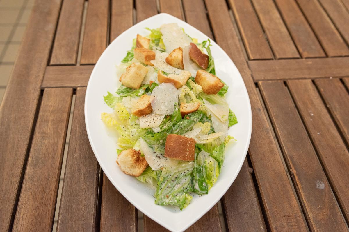 Lettuce salad served on a leaf shaped white dish
